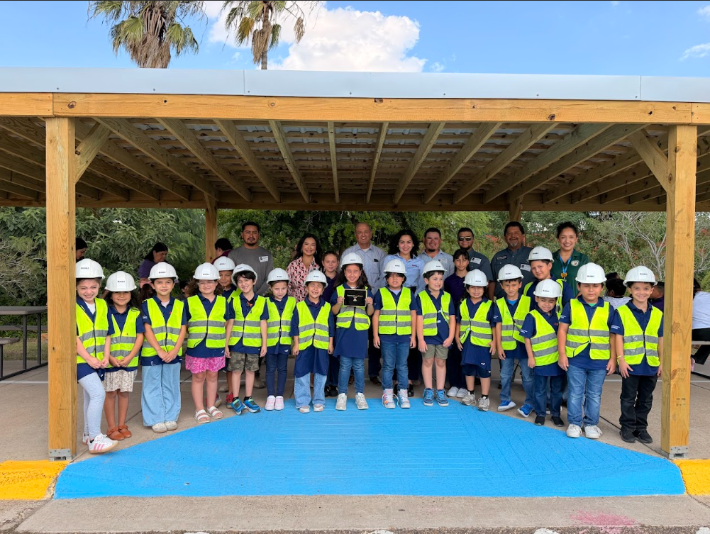 Student construction workers posing with Noble Construction employees.