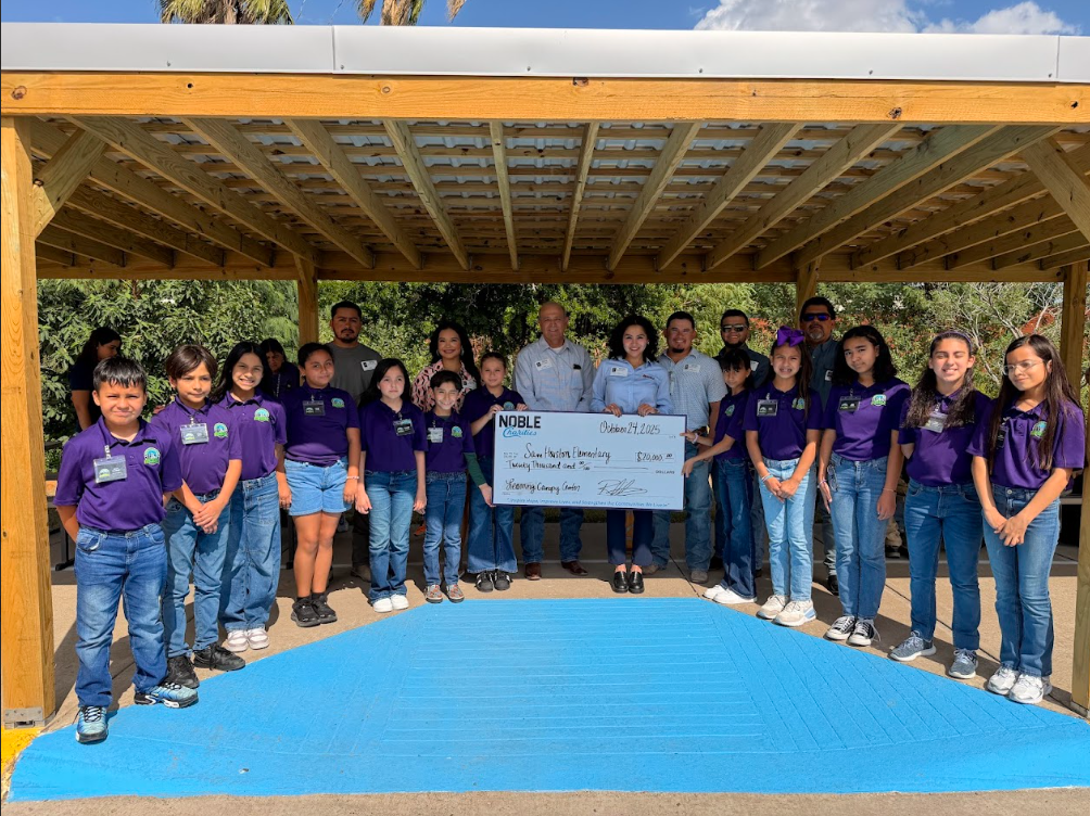 Students and adults posing with check.