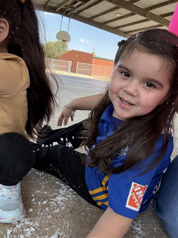 Student posing playing with snow.