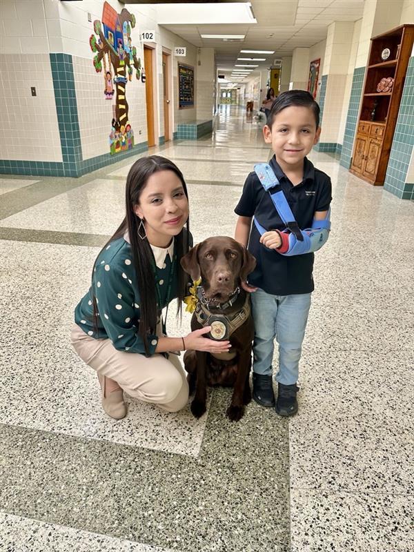 Staff and student posing with K9.