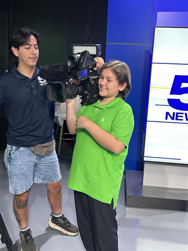 Student being taught how to use a professional camera.