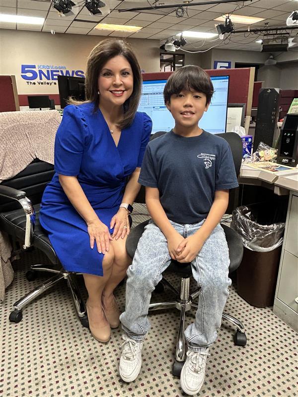 Student posing with news anchor.