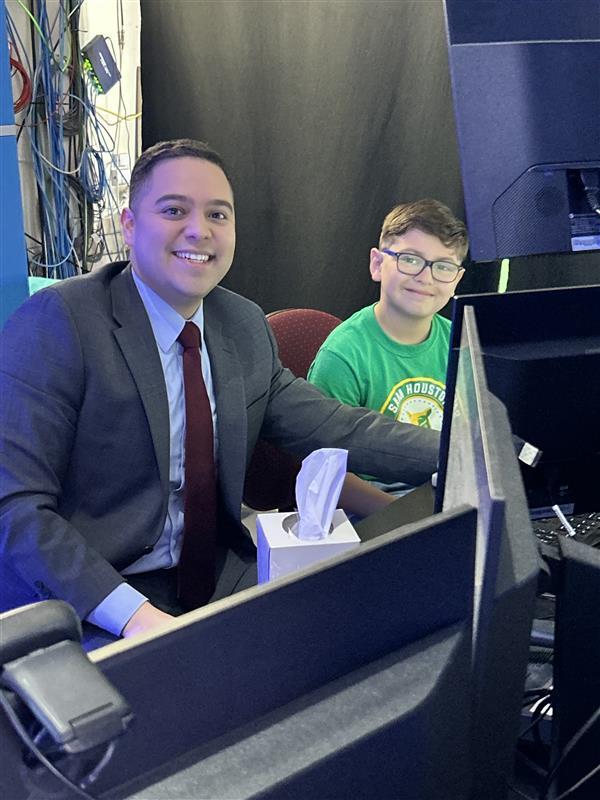 Student posing with news anchor.