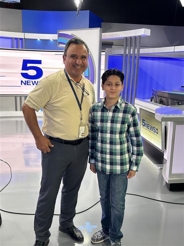 Student posing with news anchor.