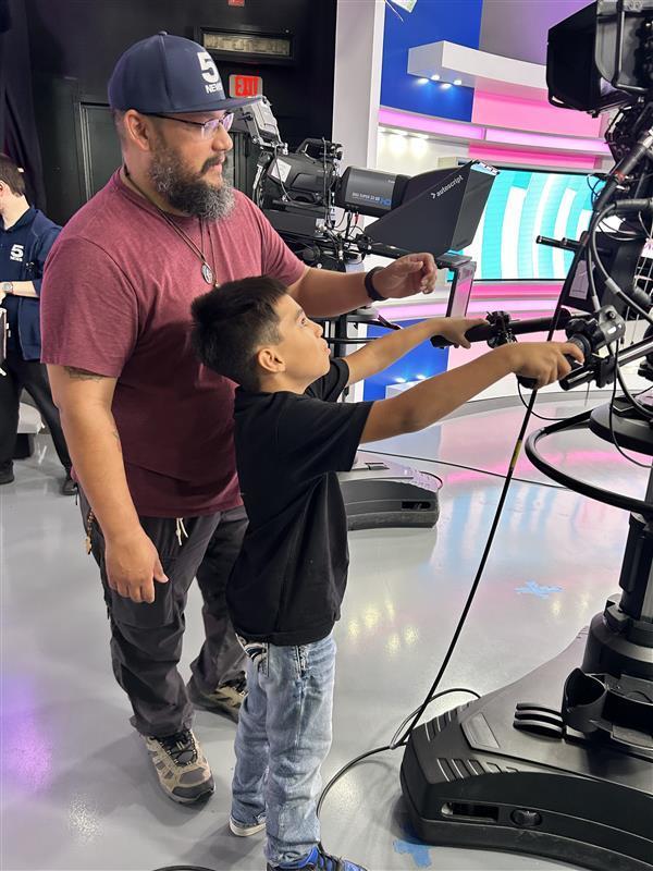 Student being taught how to use a professional camera.