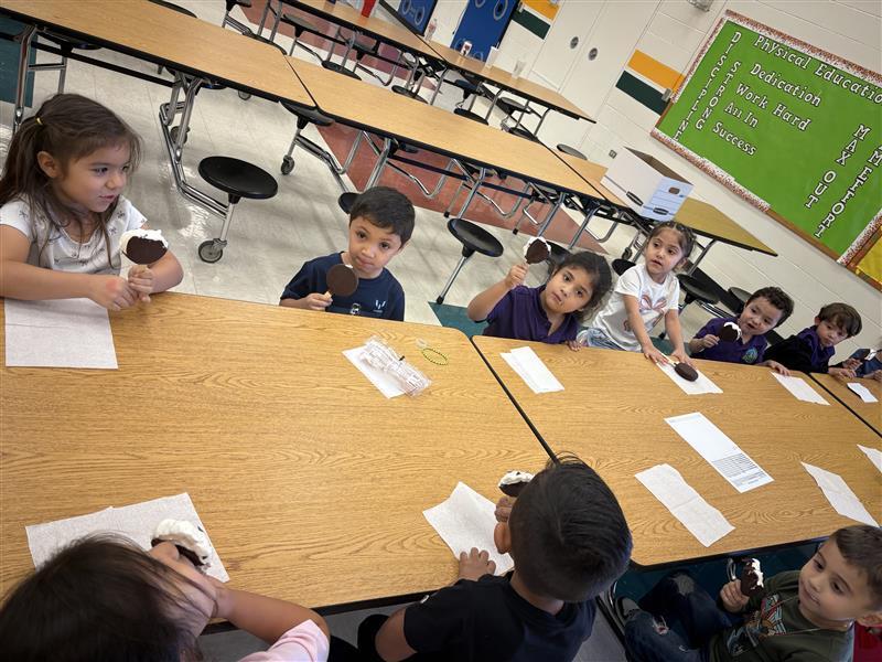 Kids posing eating dilly bar.