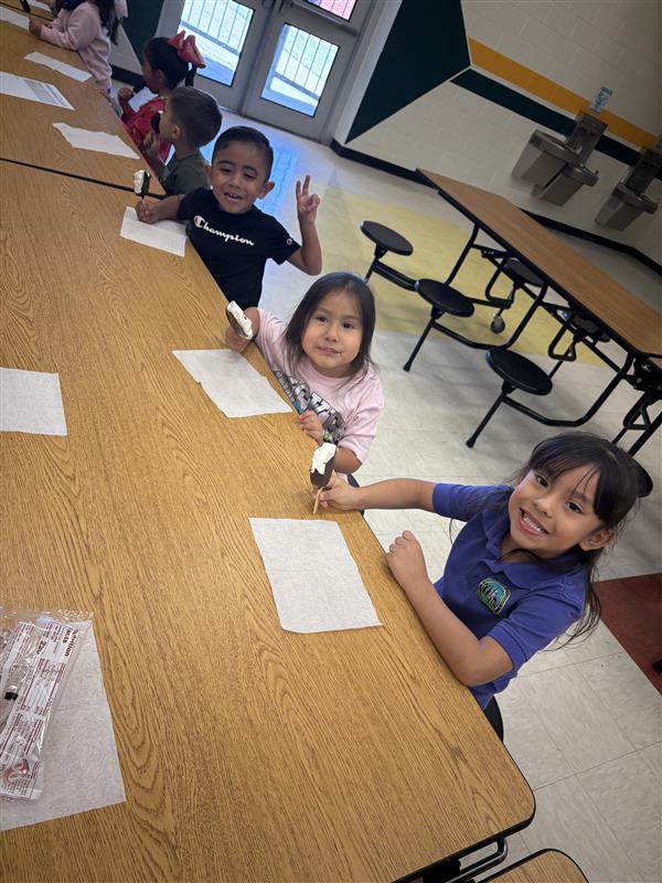 Kids posing eating dilly bar.