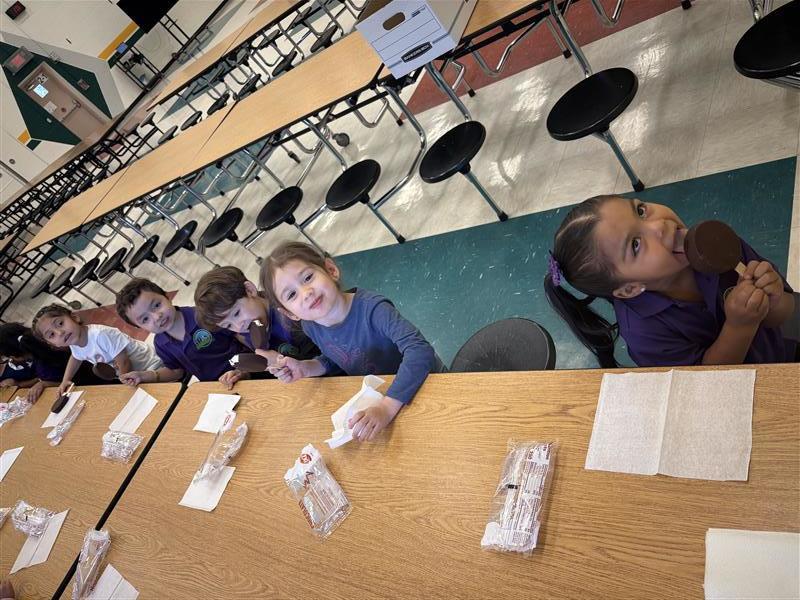 Kids posing eating dilly bar.