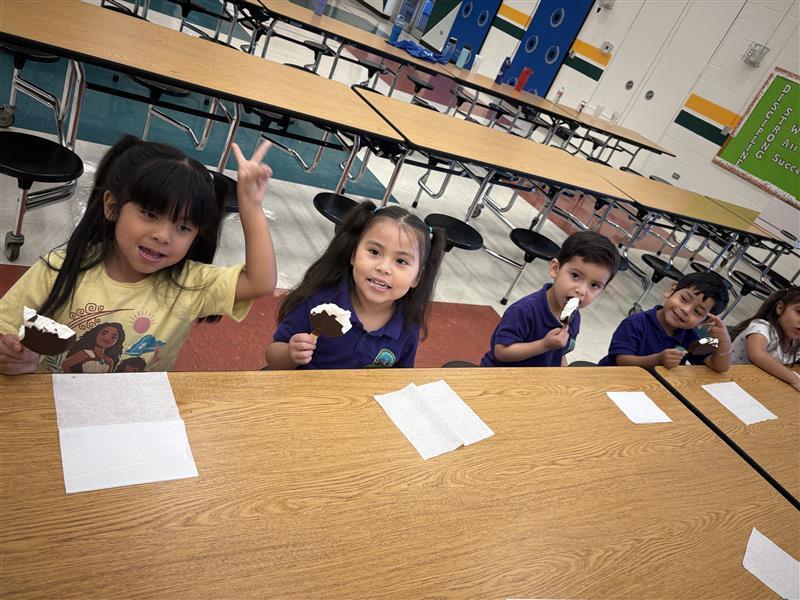 Kids posing eating dilly bar.