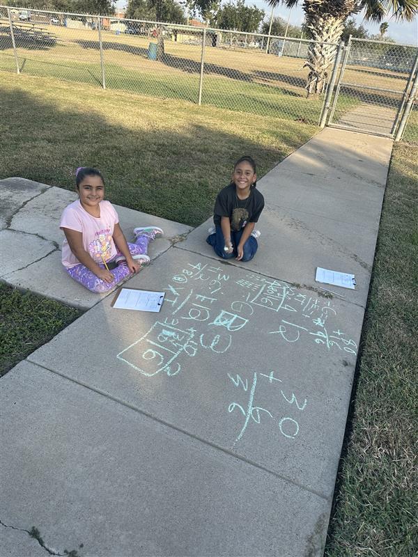 Kids posing while working on multiplication facts outside.