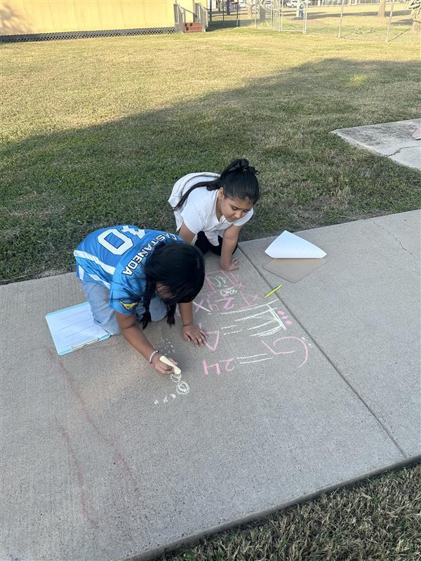 Kids posing while working on multiplication facts outside.
