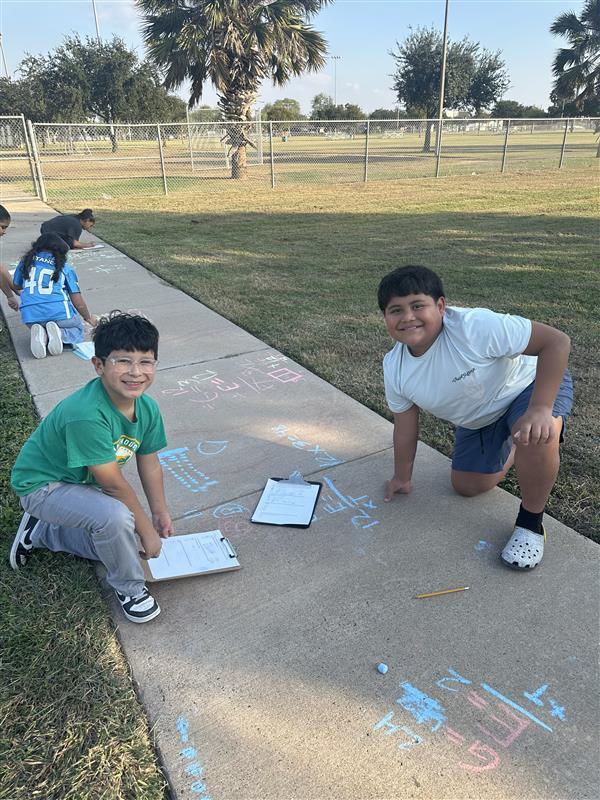 Kids posing while working on multiplication facts outside.