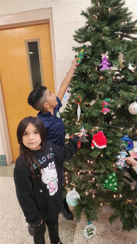 Student posing in front of Christmas tree.