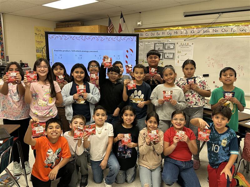 Kids posing with cookie for national cookie day.