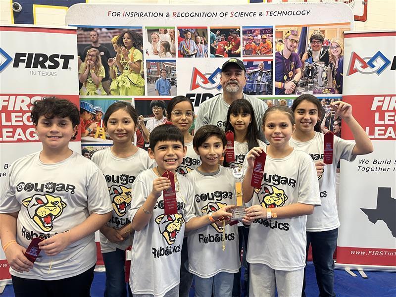 Kids posing with teacher and ribbon at Robotics competition.