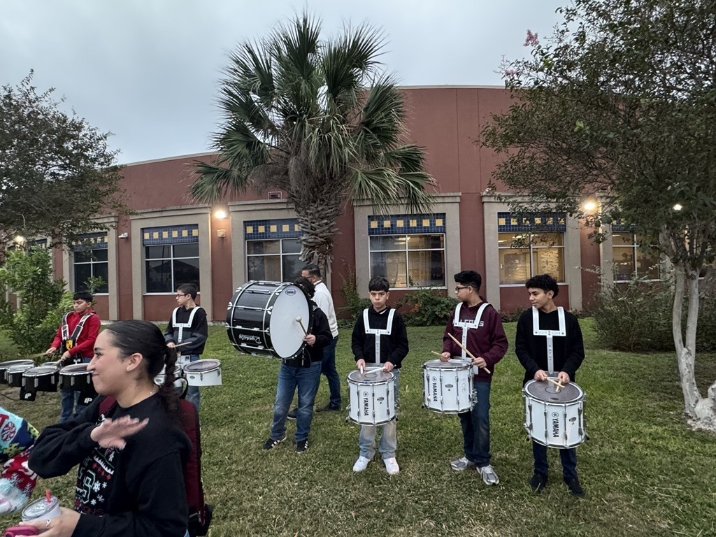 Operation Blue Santa; students and officers stand around toys that will be given to the community. 