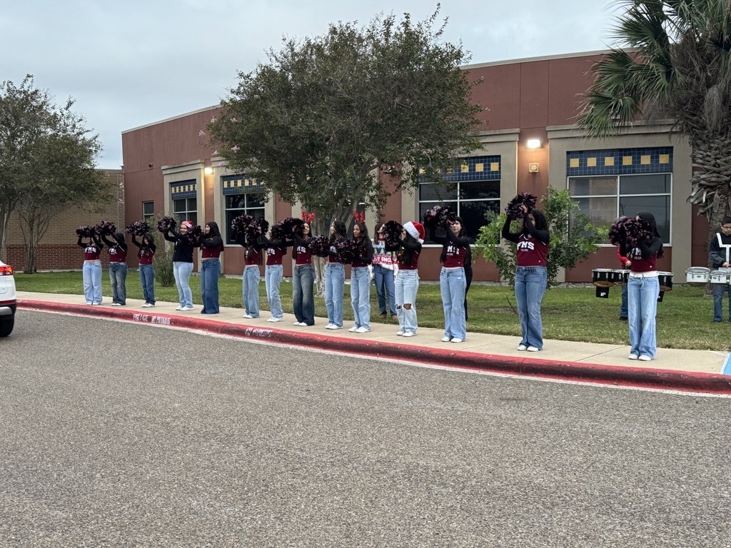 Operation Blue Santa; students and officers stand around toys that will be given to the community. 