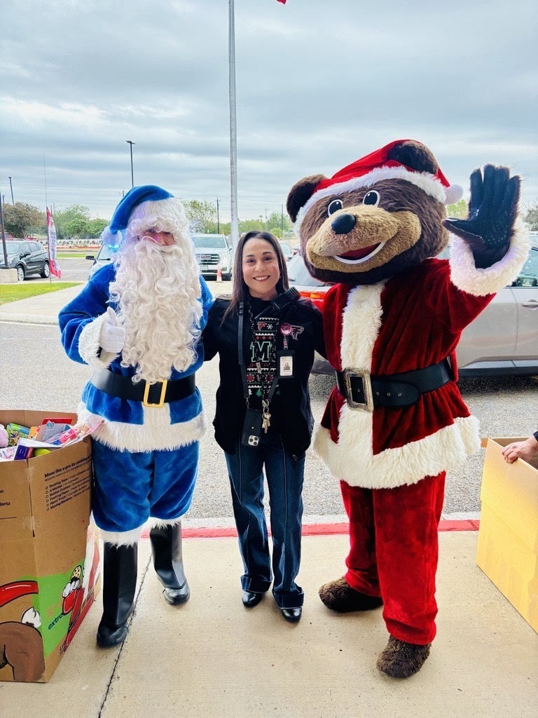 Principal Trevino stands with Blue Santa and Teddy welcoming families 