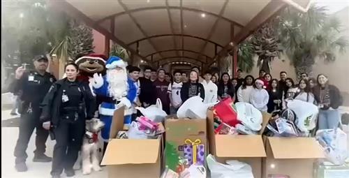 Video of Principal Trevino and Officers surrounded by students and the presents they donated for Operation Blue Santa