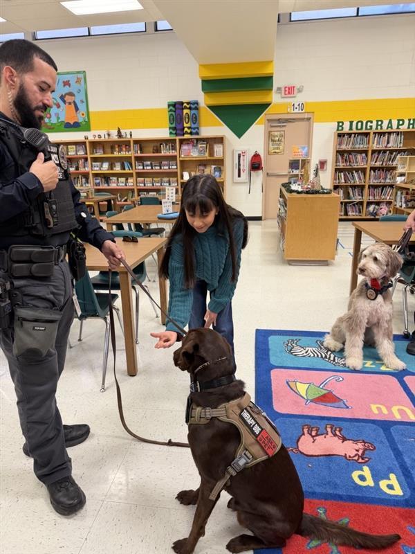 Students petting emotional support K9 officer.