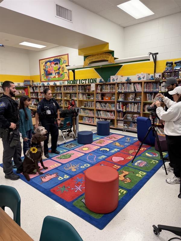 Officers and student posing with emotional support K9 officers.