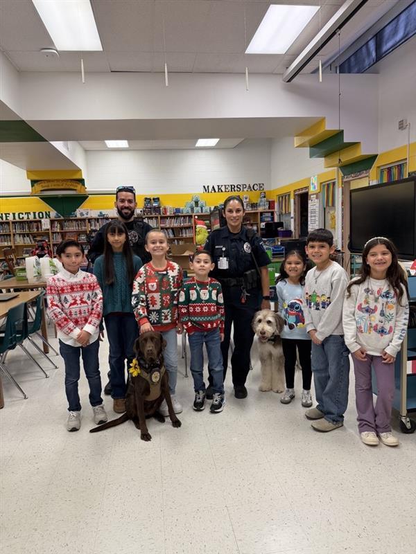 Students and officers posing with emotional support K9 officers.