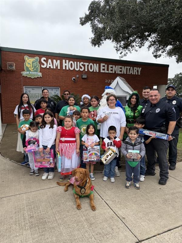 Kids posing with officers and toys.