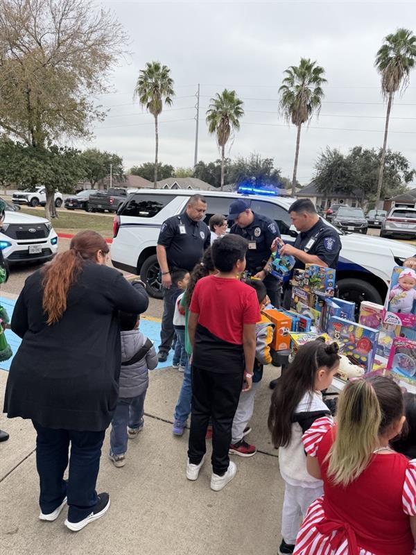 Kids receiving toys from officers.