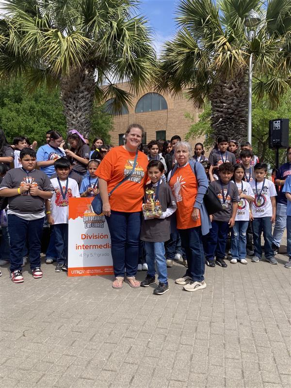 Kid and adults posing with trophy.