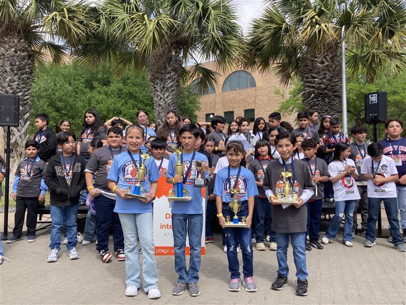 Kids posing with trophy.