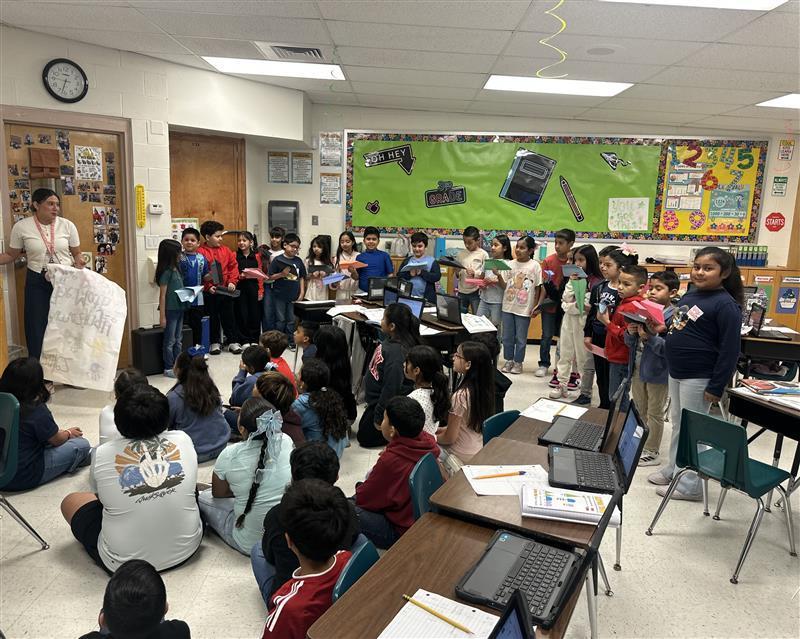 Kids sitting on floor to see presentation of STAAR motivational poster.