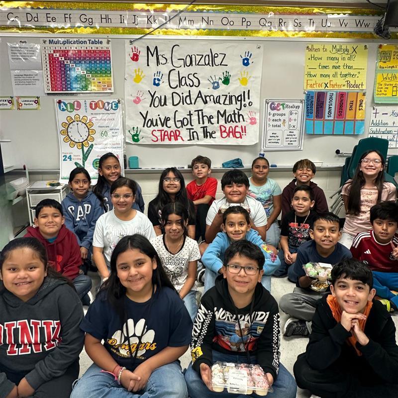 Kids posing in front of STAAR motivational poster.