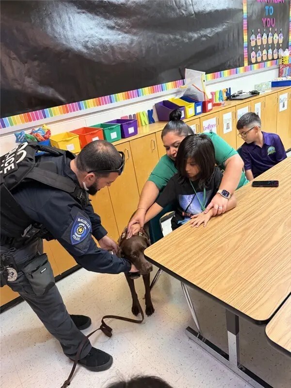 Officer and K9 officer supporting student.