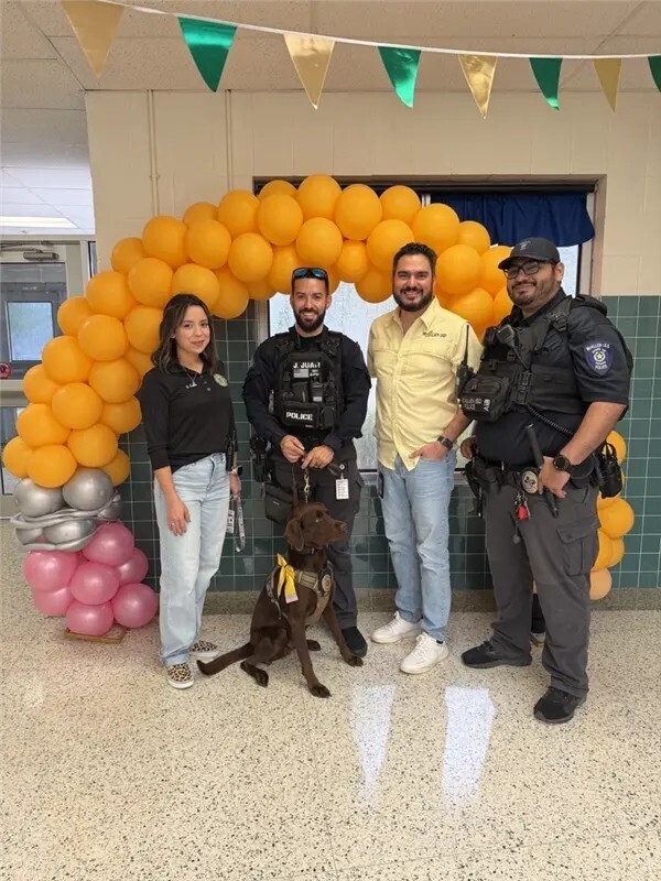 Adults posing with K9 officer.