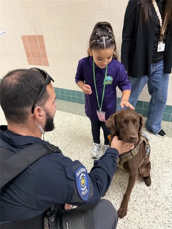 Officer and K9 officer supporting student.