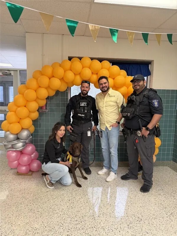 Adults posing with K9 officer.