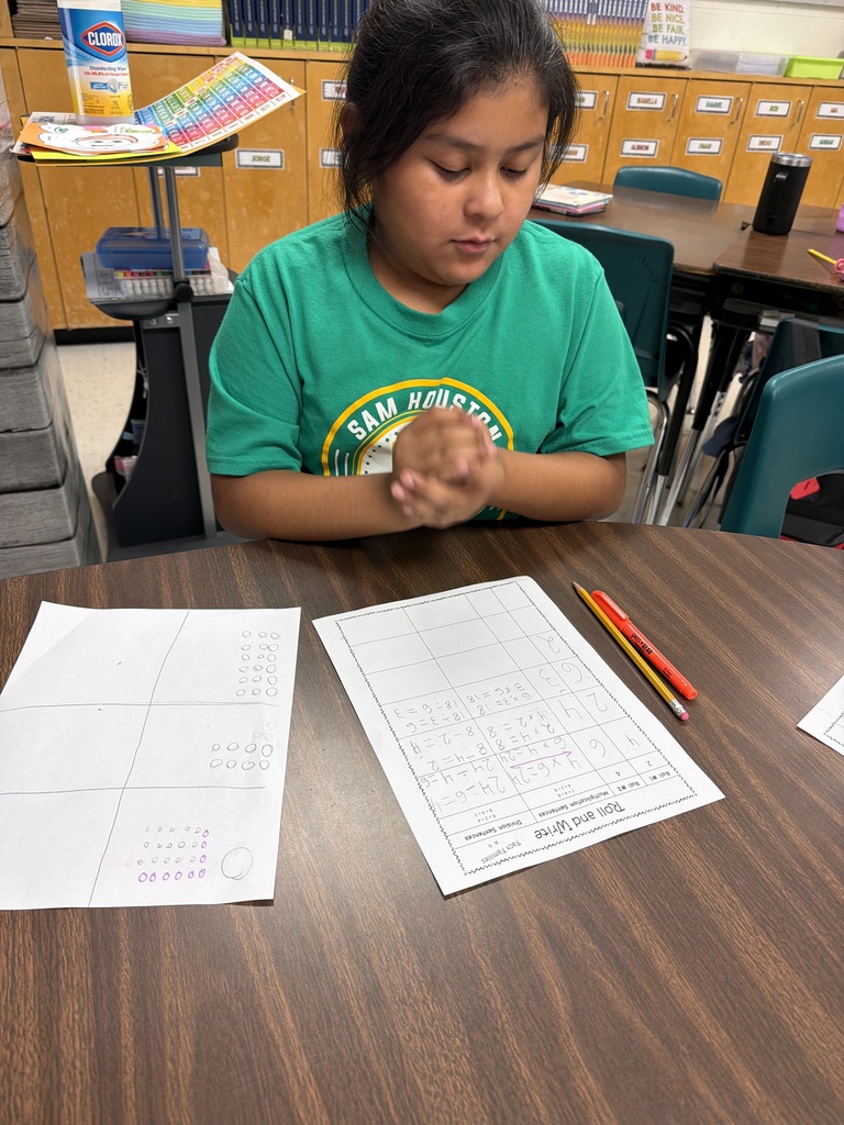 Student rolling a die to complete fact family practice.