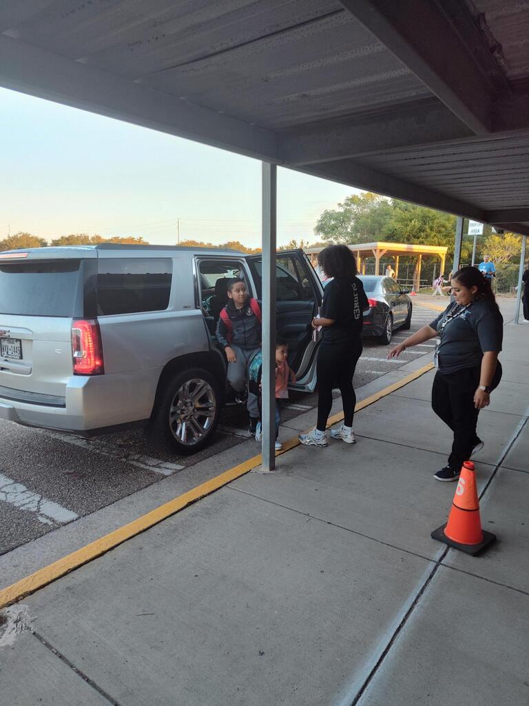 Volleyball player opening doors for student.