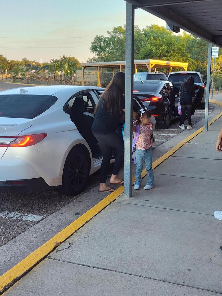 Volleyball player opening doors for student.