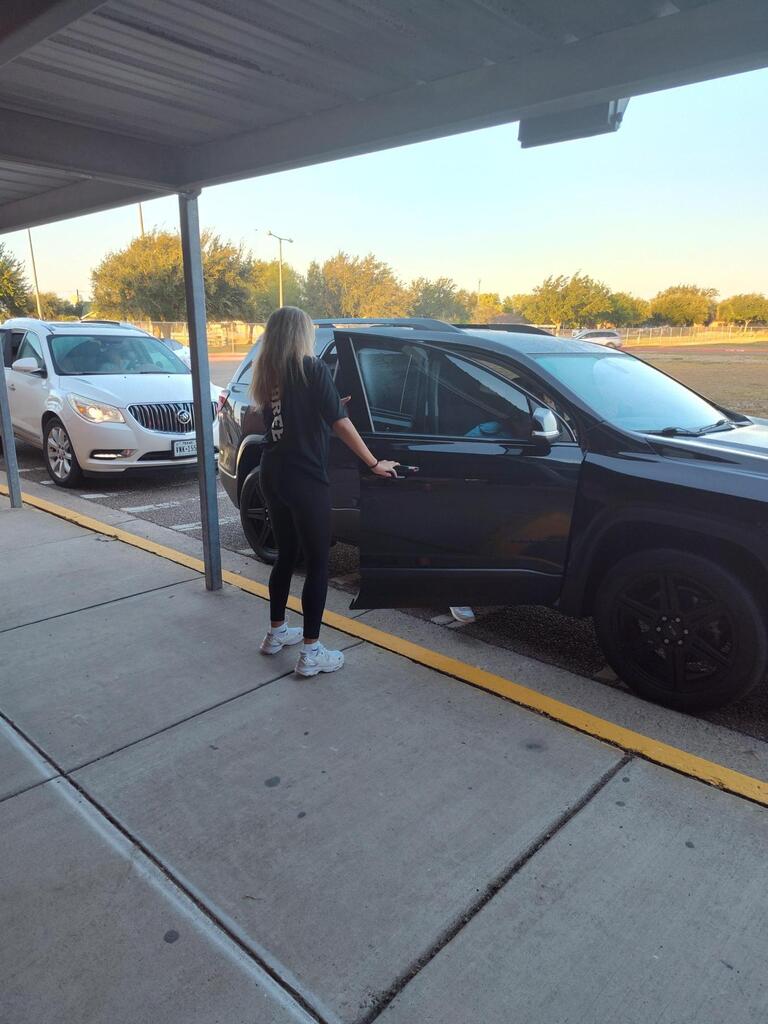 Volleyball player opening doors for student.
