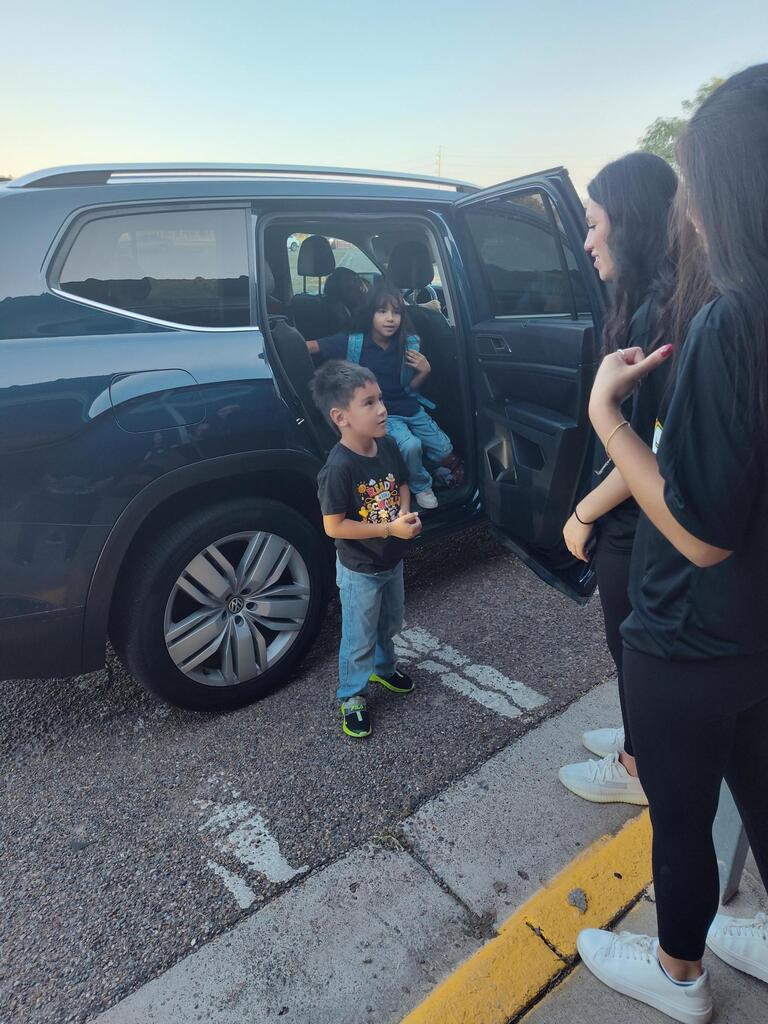 Volleyball player opening doors for student.