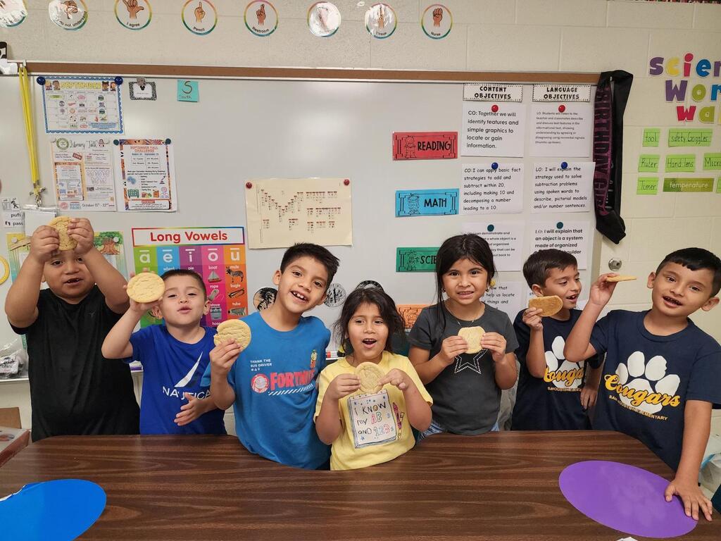 Students posing for making cookies learning activity.