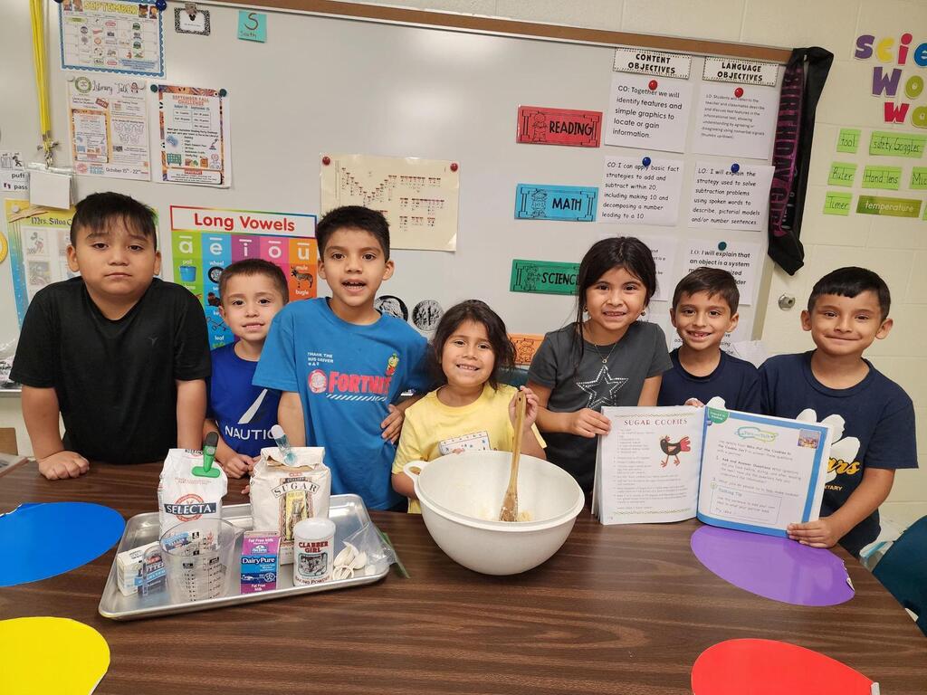 Students posing for making cookies learning activity.
