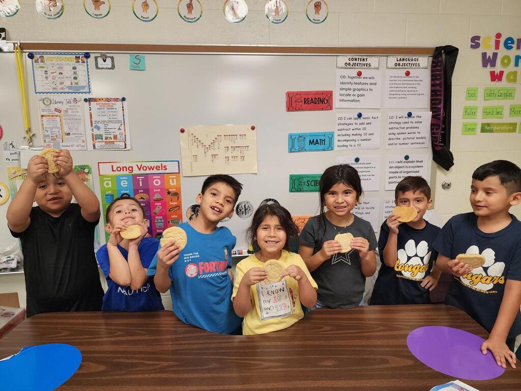 Students posing for making cookies learning activity.