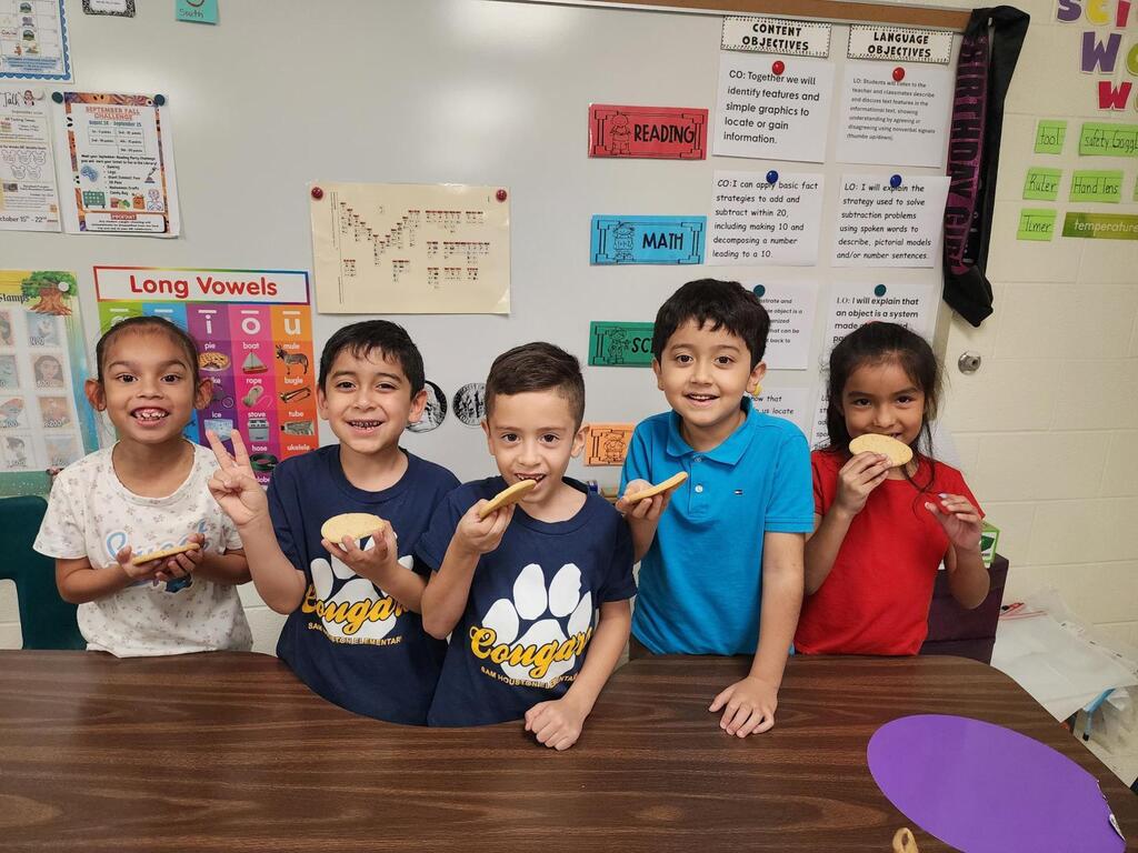 Students posing for making cookies learning activity.
