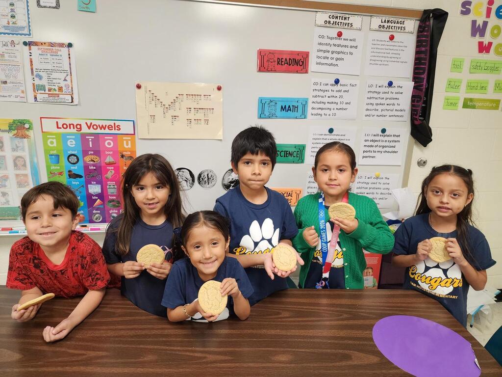 Students posing for making cookies learning activity.
