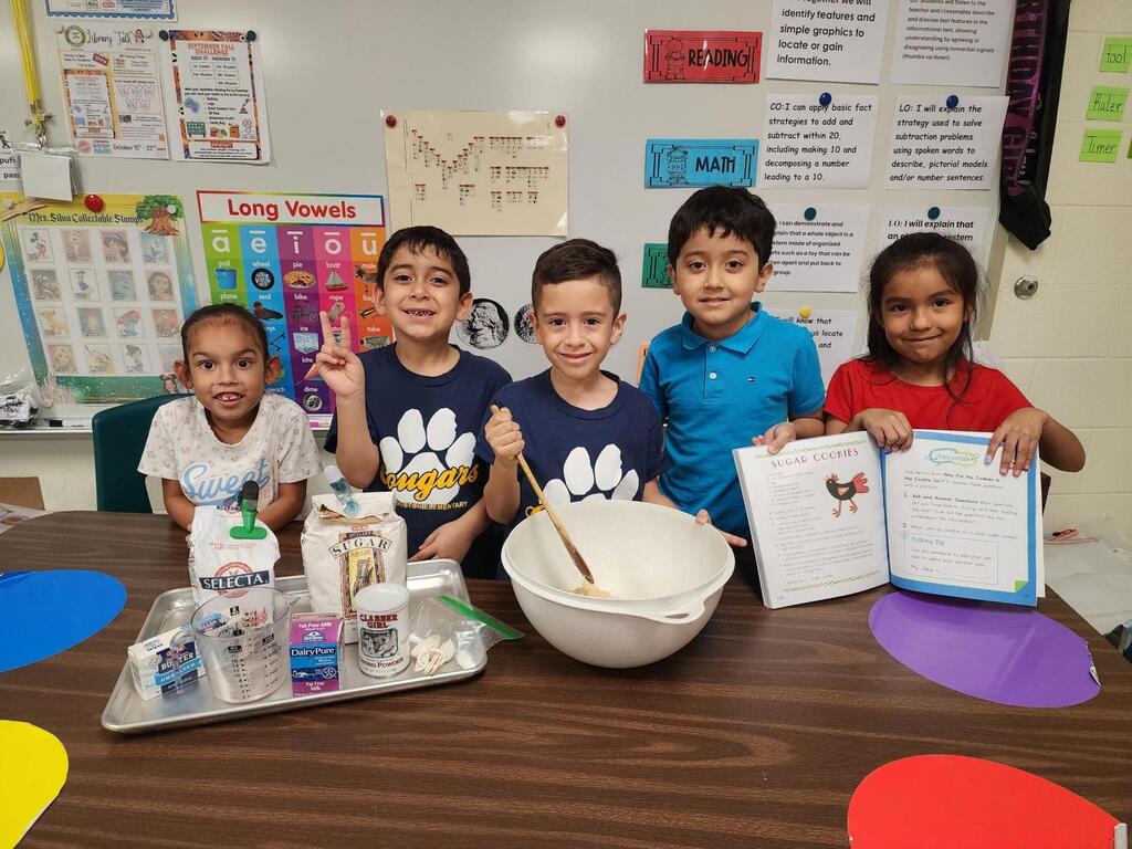 Students posing for making cookies learning activity.