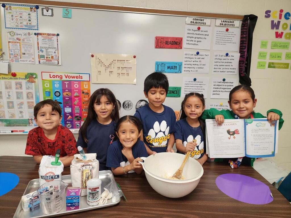Students posing for making cookies learning activity.