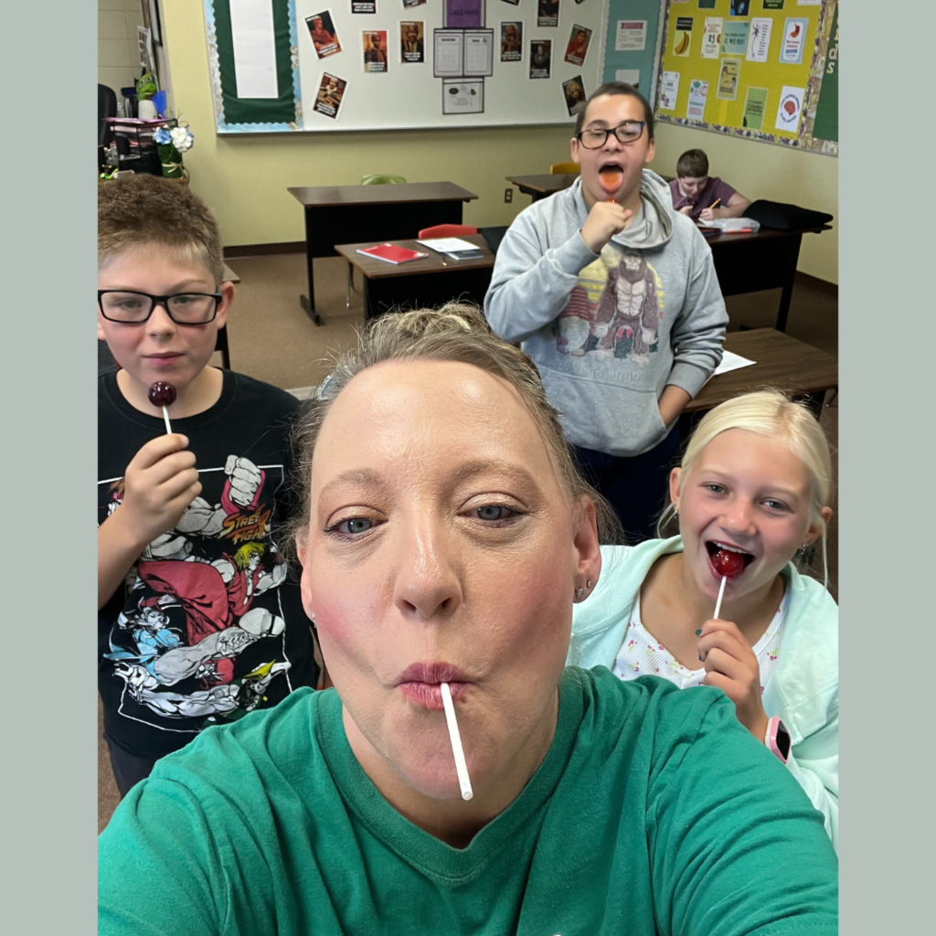 Junior high students and their teacher eating Tootsie Pops