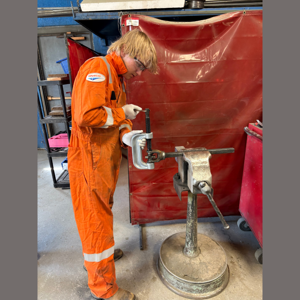 A high school student testing machinery parts in an ag lab